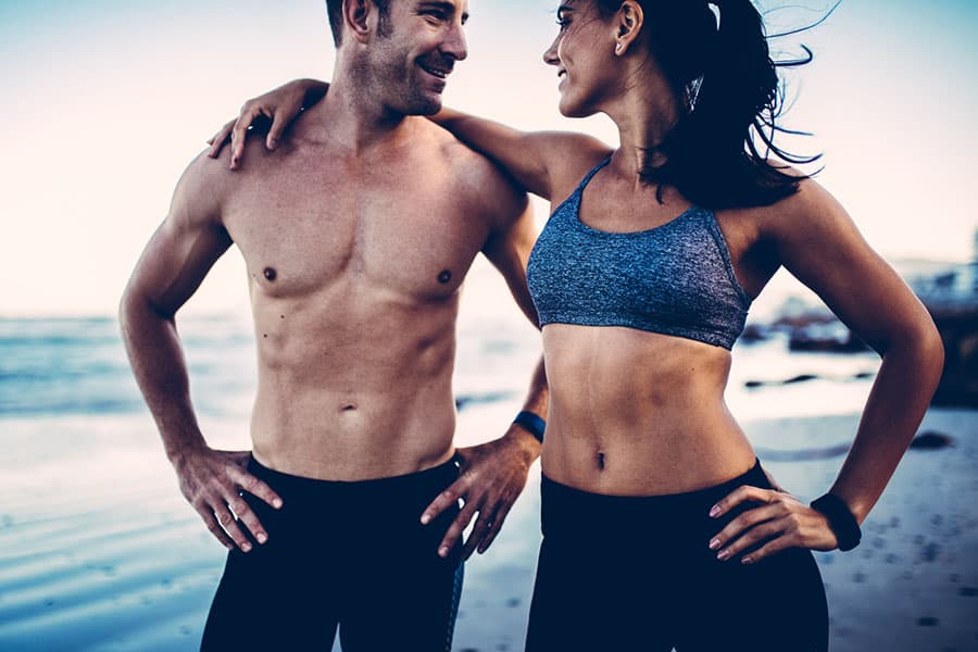 Couple flaunting their flat abdomen after doing ab workouts