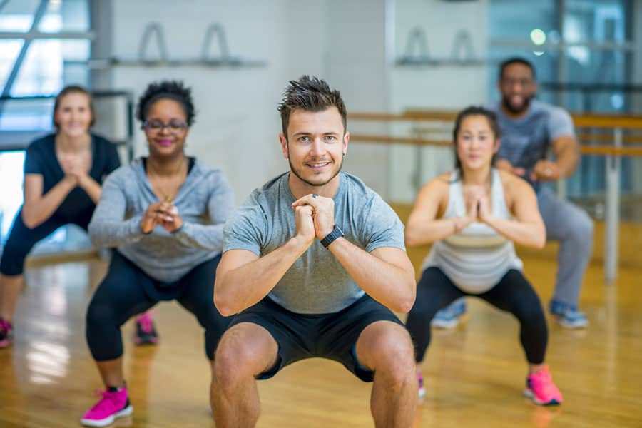 A group of adults are taking a fitness class together