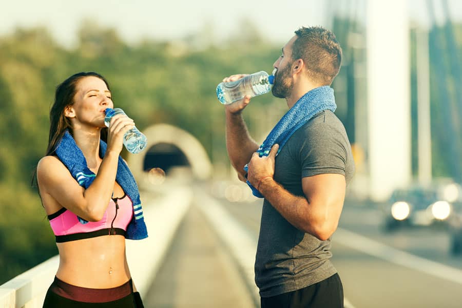 Couple drinking water after a morning jog