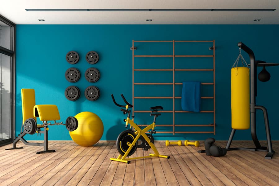 Blue and yellow themed home gym with punching boxer, indoor spin cycle and other fitness equipment