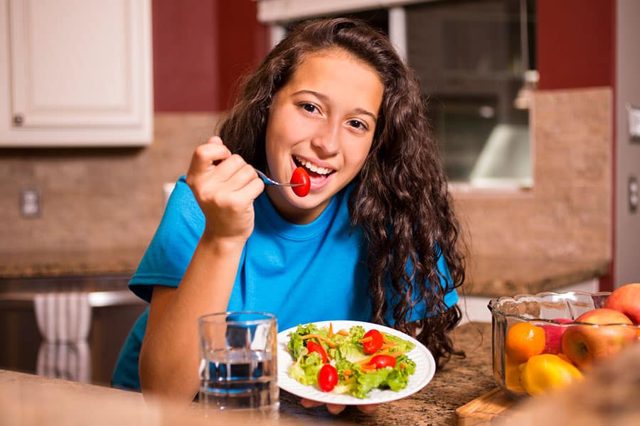 A teenage girl eating healthy snacks