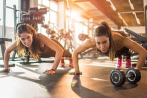 Two fit sporty girls doing push ups