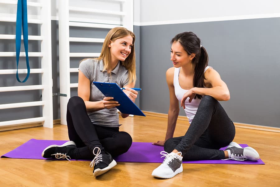 Two women discussing their workout plan