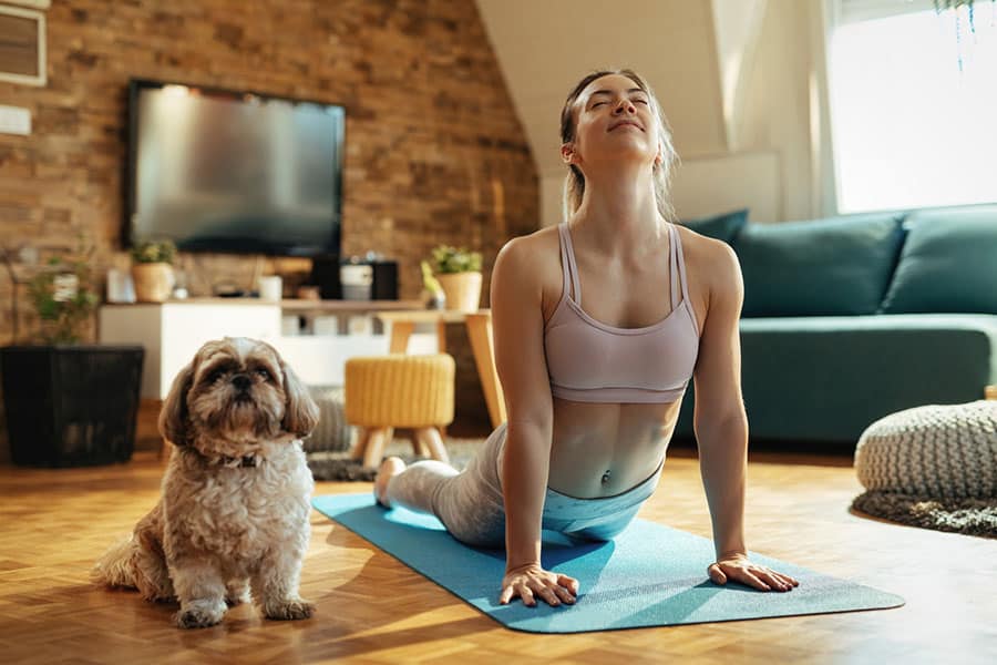 Women doing stretching exercises with her dog
