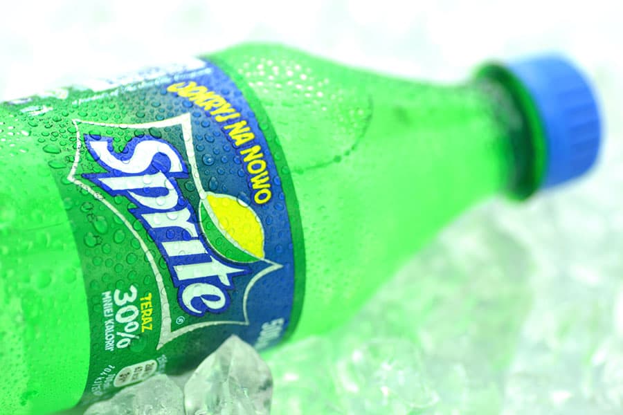 Bottle of Sprite drink on ice cubes.