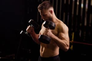 A fit man performing hammer curls with dumbbellss