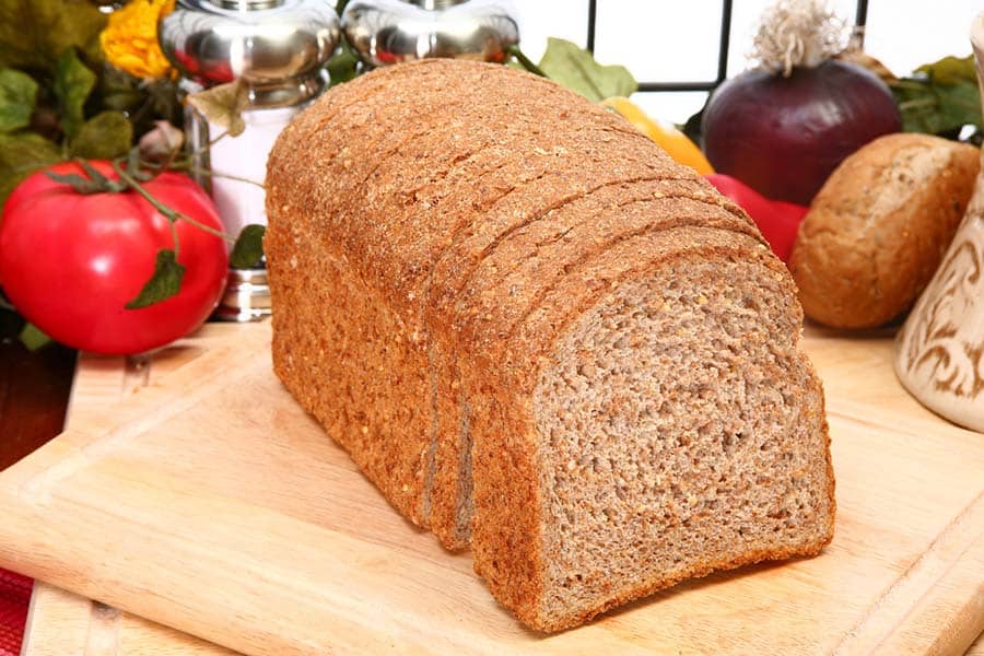 A loaf of sliced Ezekiel bread in a kitchen.
