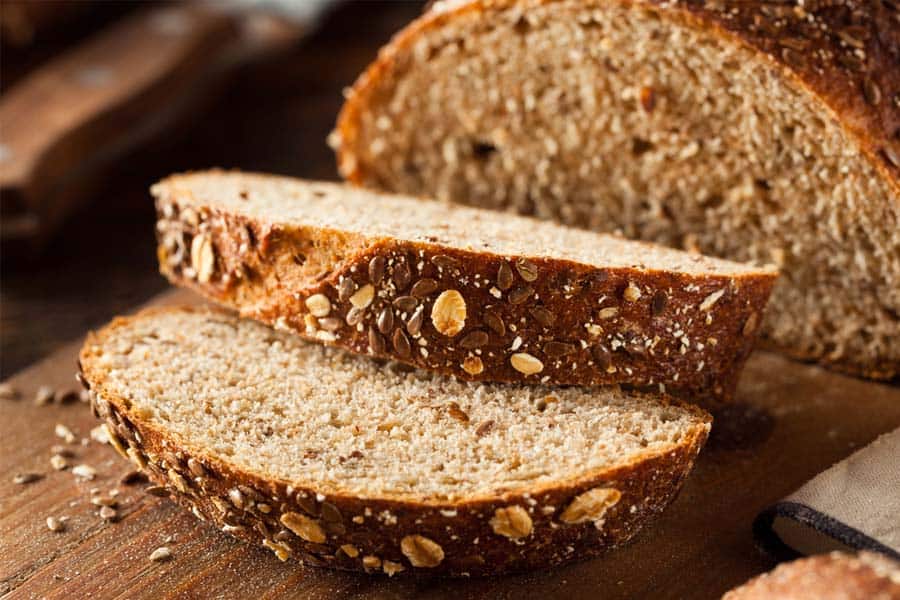 A loaf of bread sliced on a kitchen table.