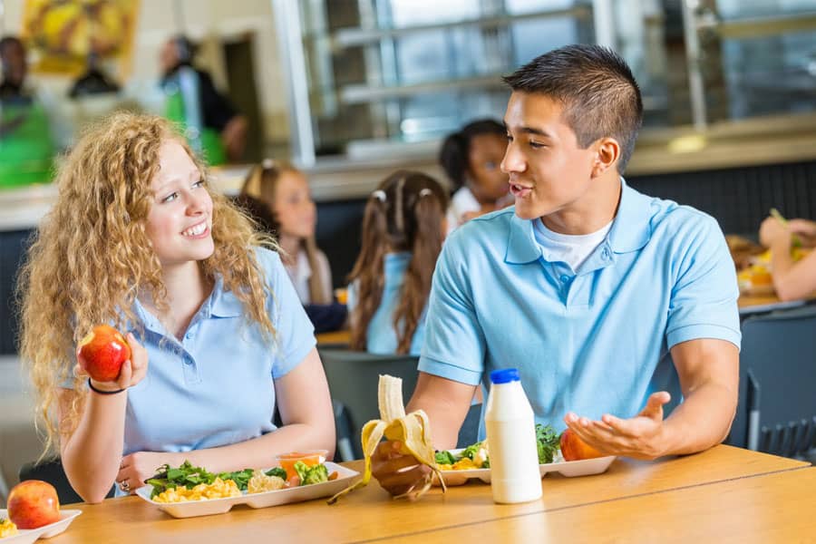 teenagers having healthy lunch together