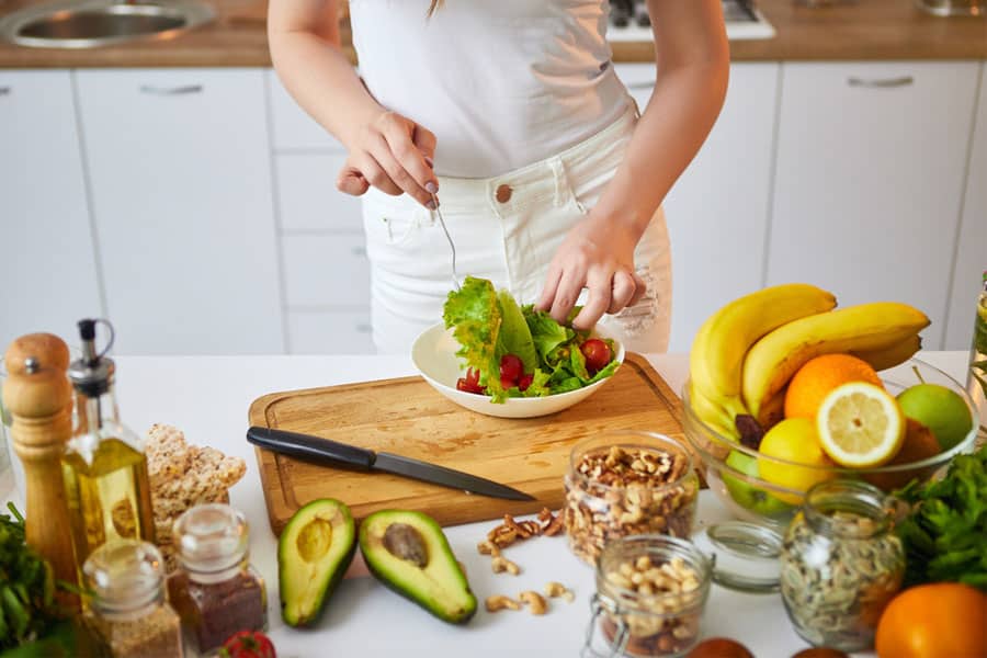 A woman is preparing a vegan meal to eat.