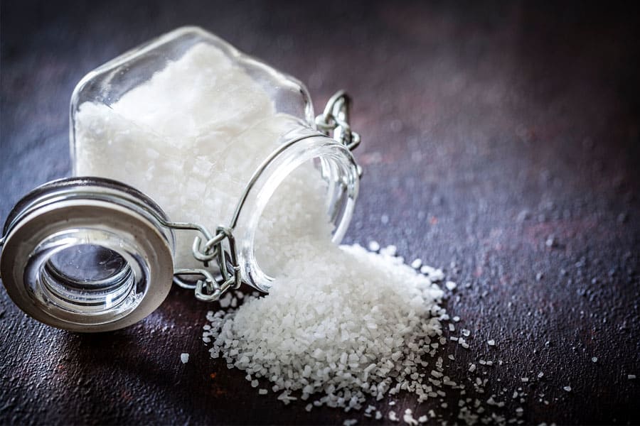 Salt is sprinkled on the table out of the salt jar.