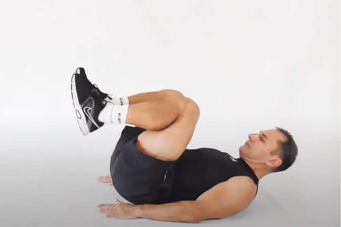 A man performing crunch kicks.
