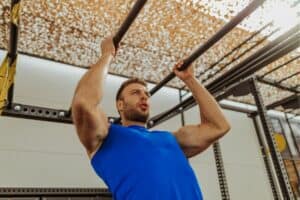 A gym enthusiast is doing neutral grip pull ups.